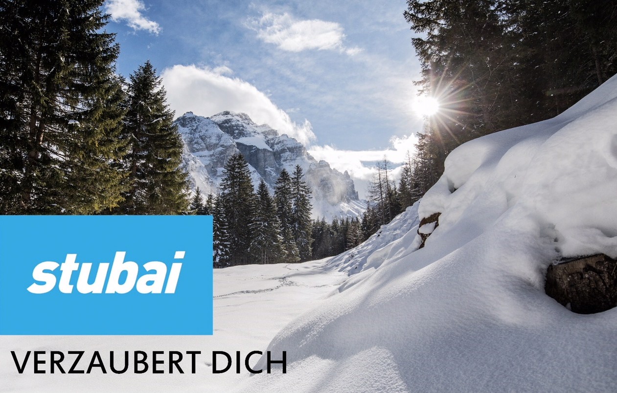 Der Werbeslogan "stubai verzaubert dich" auf einem schneebedeckten Berg im Stubaital.