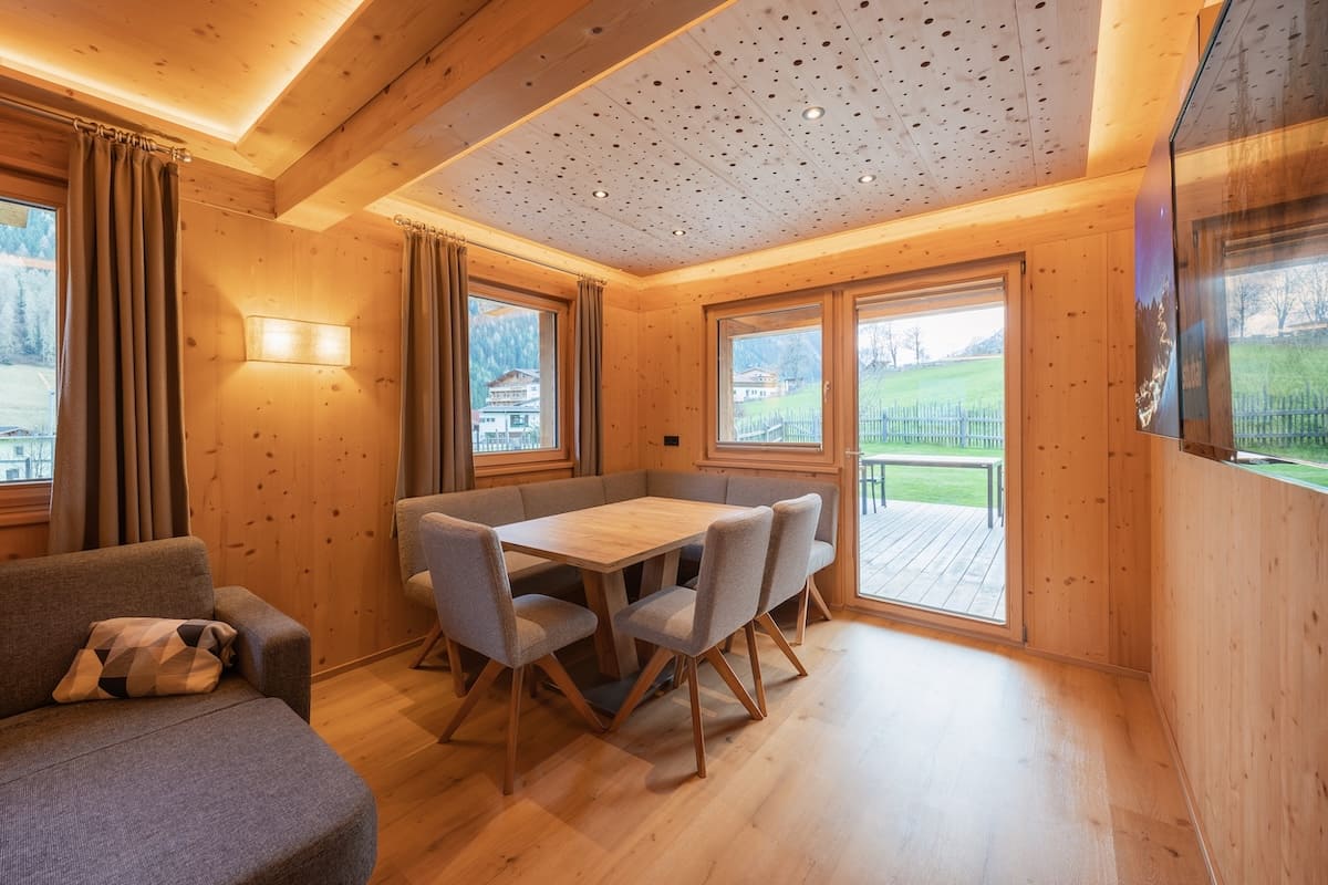 Wohnzimmer der FEWO Sonnentanz mit Fichtenholz und großen Fenstern